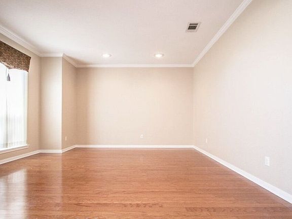 Inviting formal living room tastefully painted & shiny hard wood floors.