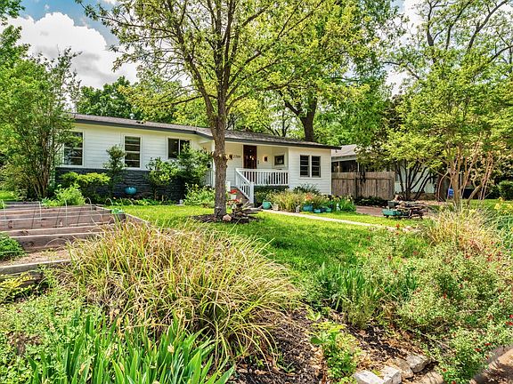 Glowing home with deep porch, shade, large vegetable/flower beds. Driveway for two cars and plenty of street parking.