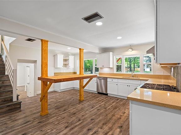 Kitchen featuring dishwasher, a sink, dark wood finished floors, and visible vents