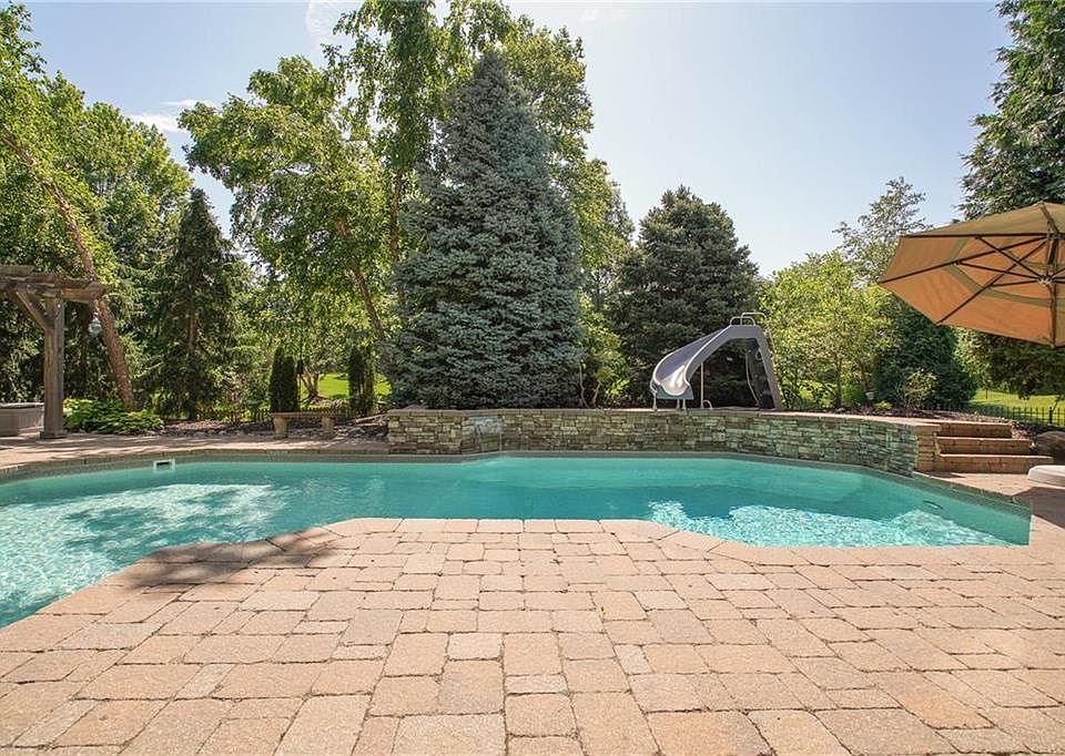 Gorgeous landscaping, saltwater pool with waterfall & slide, expanded paver patio, built-in grill, fire pit & large yard are waiting for you!