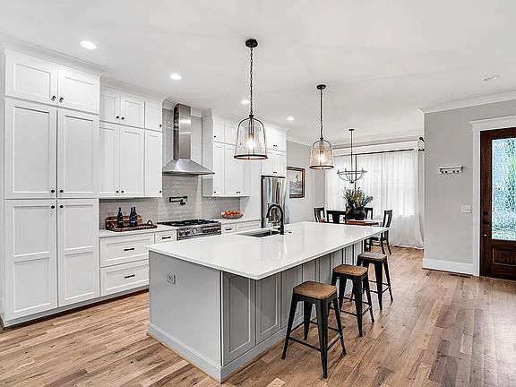 Eat in chef's kitchen with 5 burner stainless steel gas range. Ample table and island seating.