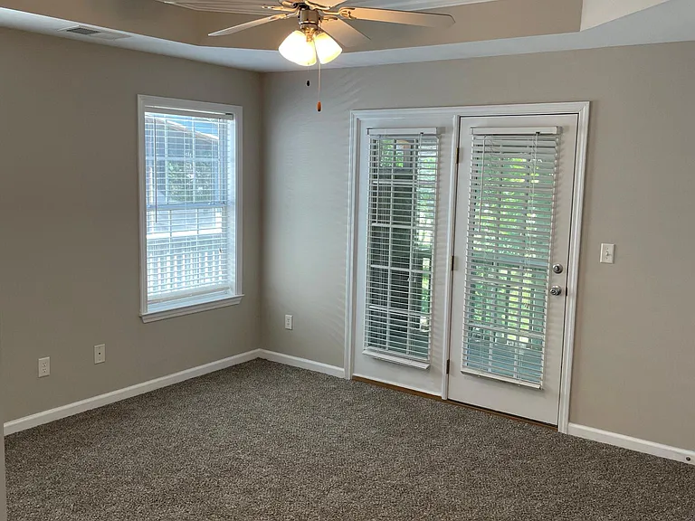 MASTER BEDROOM WITH FRENCH DOORS TO SCREENED PORCH AND NEW CARPET AND TRAY CEILING.