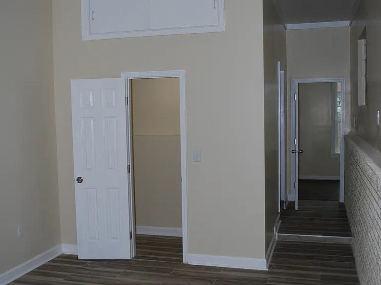 Master bedroom walk in closet with overhead storage.
