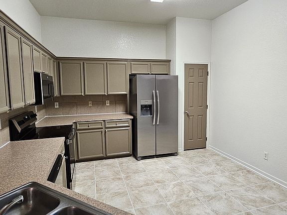Kitchen area, with new tiles, kitchen cabinets and a Brand new fridge, stove, microwave. Well lit and spacious.