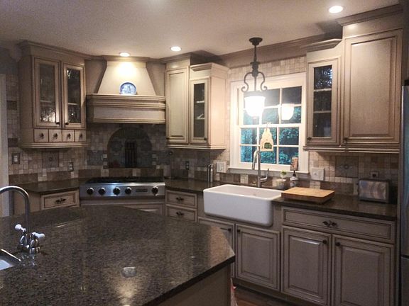 Custom kitchen w/ antique glass, farm sink, service windo to covered deck, island with veggie sink, overhead lighting