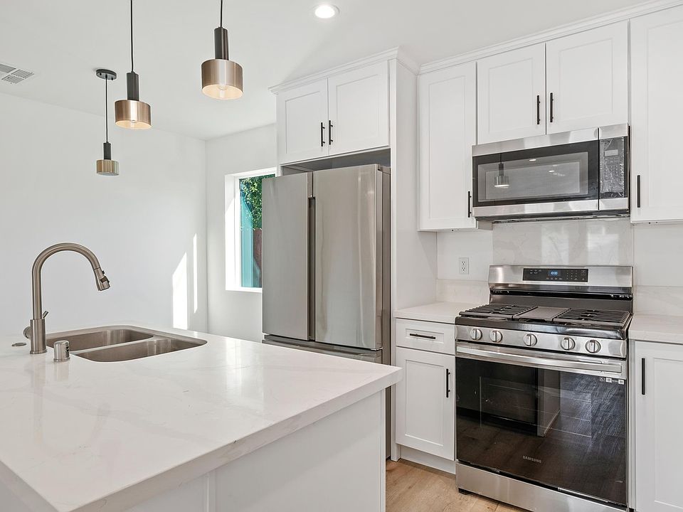 Quartz countertops, island with seating, stainless steel appliances