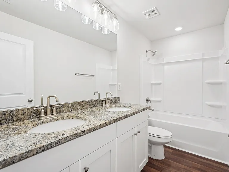 Secondary bathroom with tub shower and double vanity.