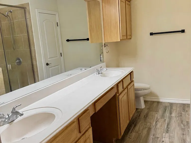 Primary bathroom, dual-sink vanity, tile flooring, abundant cabinet space