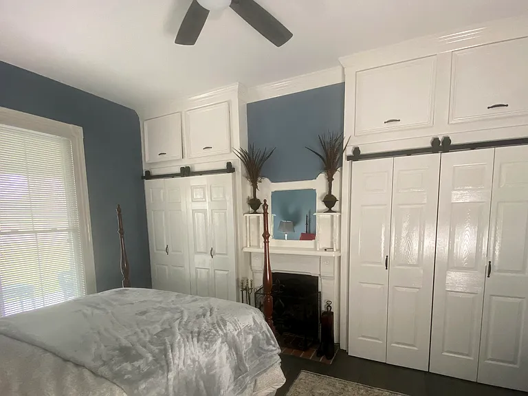View of primary bedroom from hallway: ample storage. Queen sized four poster bed. Seasonal decor included in furnishings.