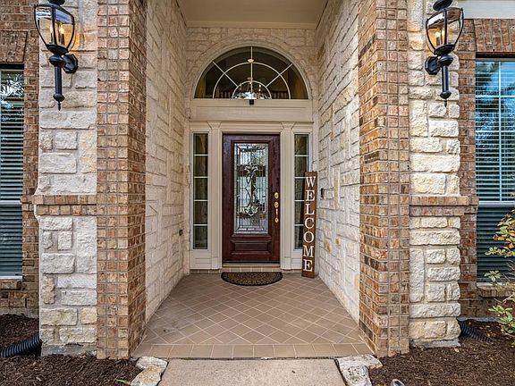 Slow down! We need a moment to admire this stunning porch! From the elegant glass panned door w/ framing windows, the textured stone & brick, to the tile - I'M ALREADY IN LOVE!