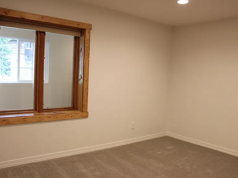 Primary bedroom with windows onto private hallway.