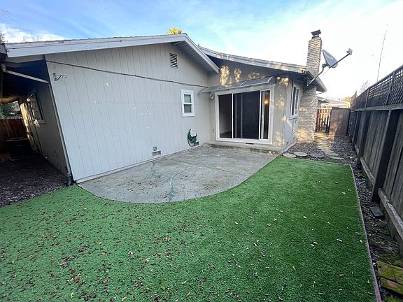 Fenced backyard with artificial grass