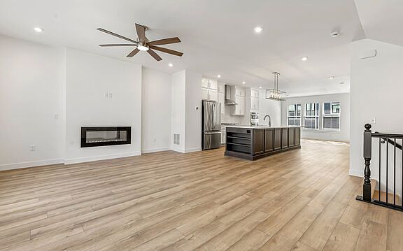Living area looking into kitchen with dining area in the background. Stairs down to ground floor.