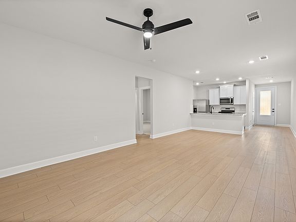 The kitchen, dining room, and living room are connected, creating an open-concept layout.