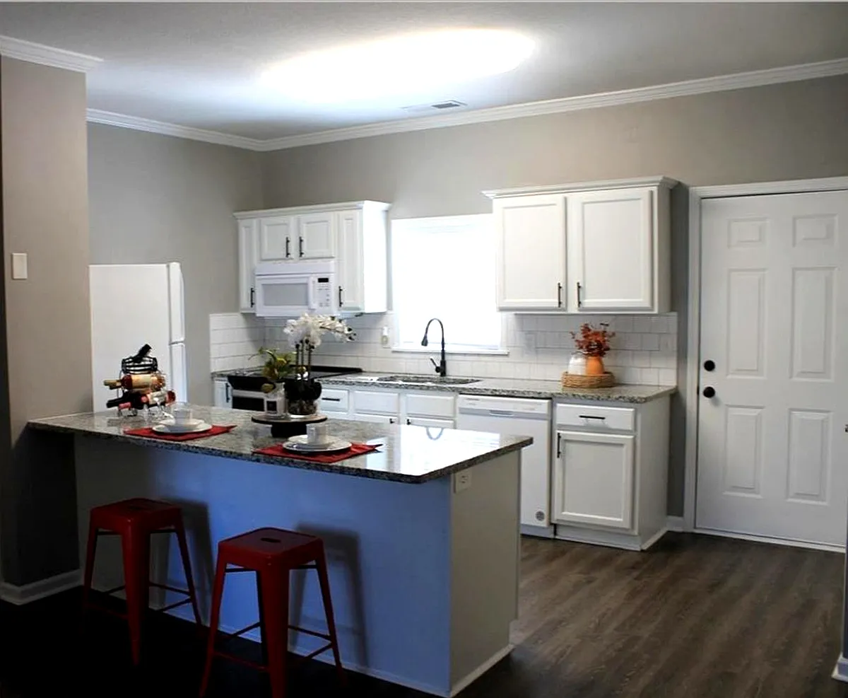 Open concept kitchen with white cabinetry, white appliances, a kitchen bar, and sink - 27 Corinth Rd