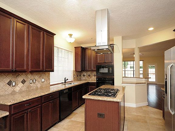 And, speaking of kitchens, this one rocks!  Dark stained cabinets, granite, tile, and black appliances.