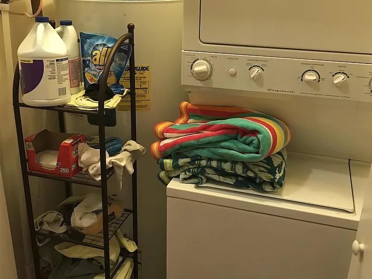 Laundry room equipped with cleaning supplies and Washer/Dryer.