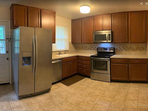 Kitchen has dining nook, tile floors, stainless steel appliances, built in microwave, wall pantry (left side of door).