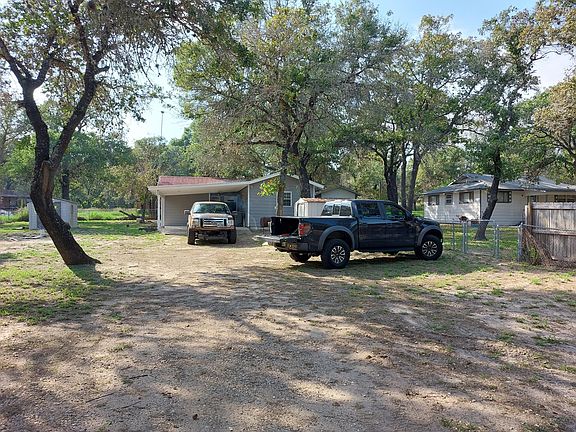 As we move closer to the house from the street the photo continues to show how large the lot is. Behind the truck backed in is a very nice & thick concrete slab that can be used for a carport & a patio.