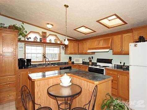 Cook your favorite meal in this lovely airy kitchen.  Lots of wood cabinets for storing your culinary tools.  Grab a snack at the island or chat with those in the family room.  Convenience and energy savings of a new dishwasher, new french doors and some new windows.