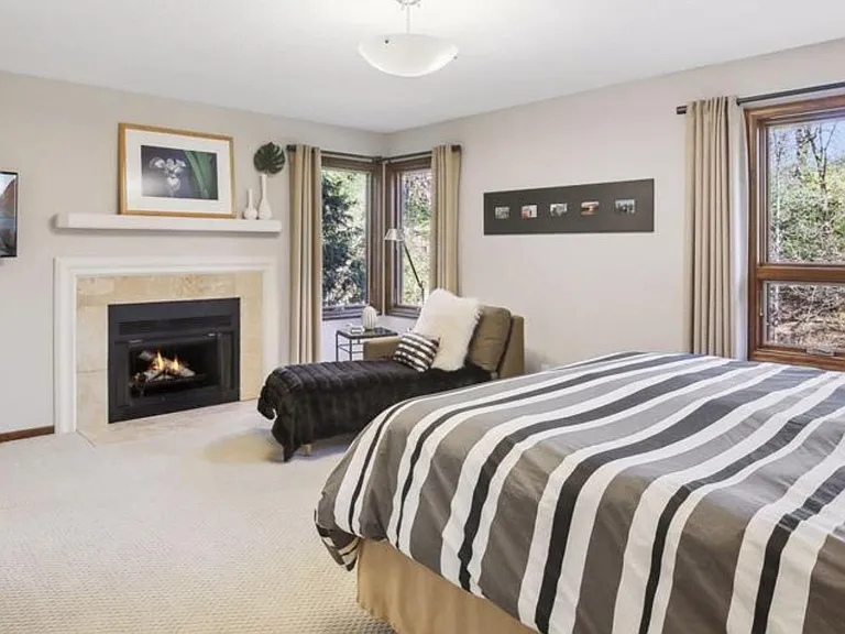 Huge master bedroom with fireplace and soothing views
