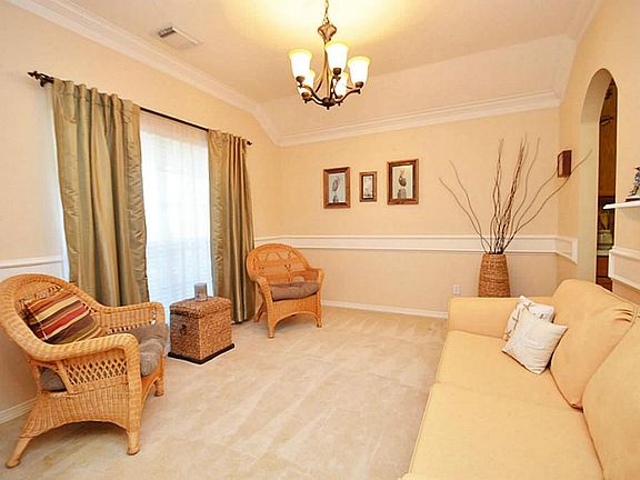 Front formal living or formal dining room with a beautiful chandelier and large crown molding. Round