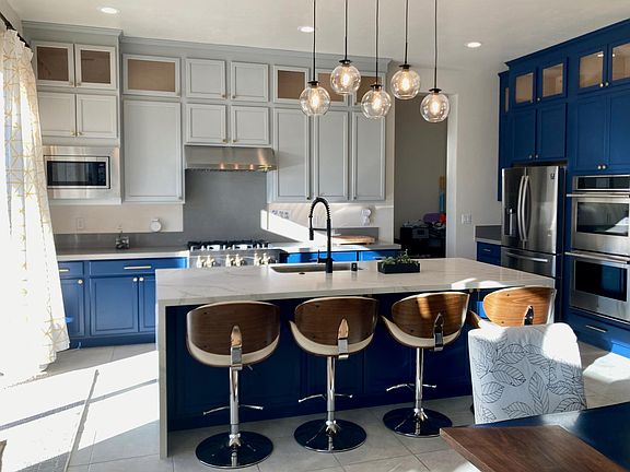 Fully stocked chef's kitchen w/ professional 6 burner gas stove, dual ovens, massive pantry, and more.