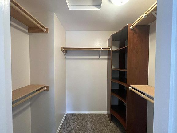 large walk-in closet with five separate shelves and built-in storage organizer
