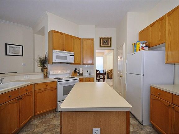 Spacious island kitchen with white appliances
