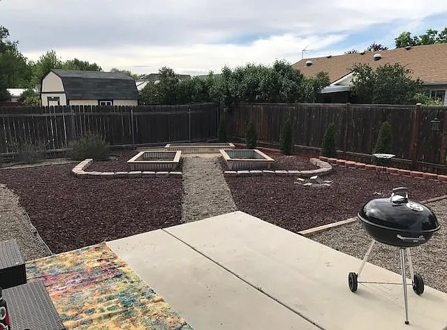 Backyard partly fire pit and garden bed area.