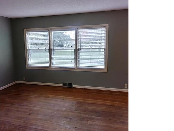 Living room wall of windows overlooking park like back yard