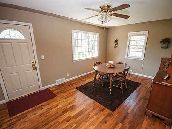 Formal dining room (17x11) entrance from front door with ceiling fan, white trim and oak floors.