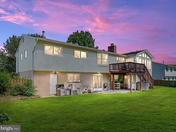 Backyard view of lower-level patio and upper-level deck.