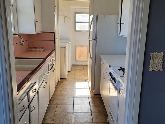 kitchen with refrigerator, oven, washer and dryer plus door to backyard