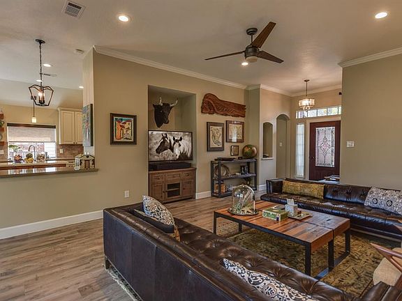 Large family / living room has recently updated Italian wide plank wood-like porcelain tile floors throughout, neutral paint tones compliment the space. Notice the art niche as you walk in to the entry.