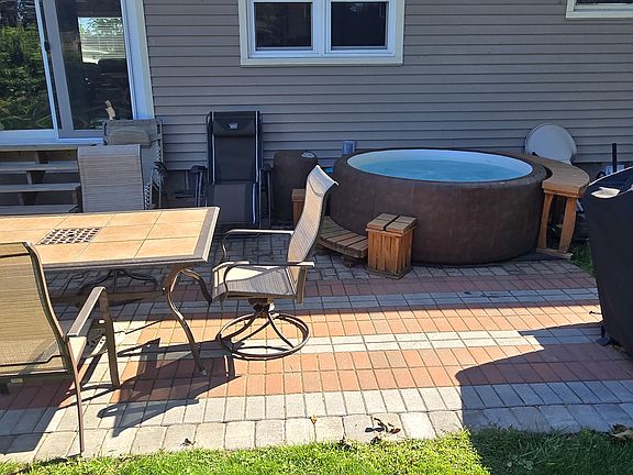 Backyard patio with hot tub, table and grill just a few steps from the kitchen