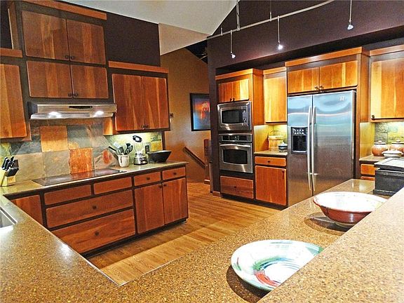 Open concept kitchen w/ custom cherry cabinets, quartz countertops & bar height counter.