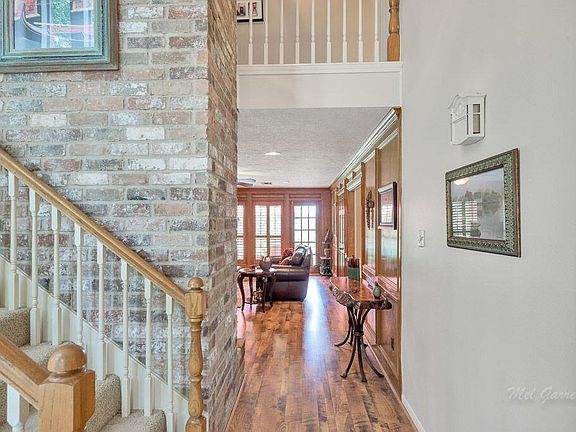 Gleaming floors lead from the entry to the den.