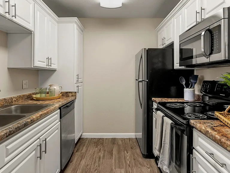 For the culinary enthusiasts, our galley-style kitchen awaits with stainless steel appliances, ample counter space, and abundant cabinetry.