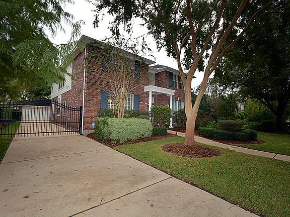 Home has an oversized garage with built in workshop area as well as storage and great security gate.