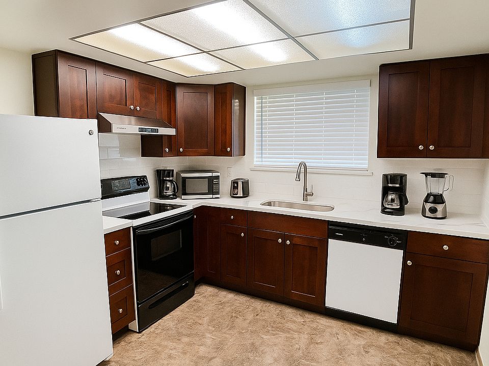 Newly renovated kitchen with new pearl-white quartz countertops and espresso cabinets.
