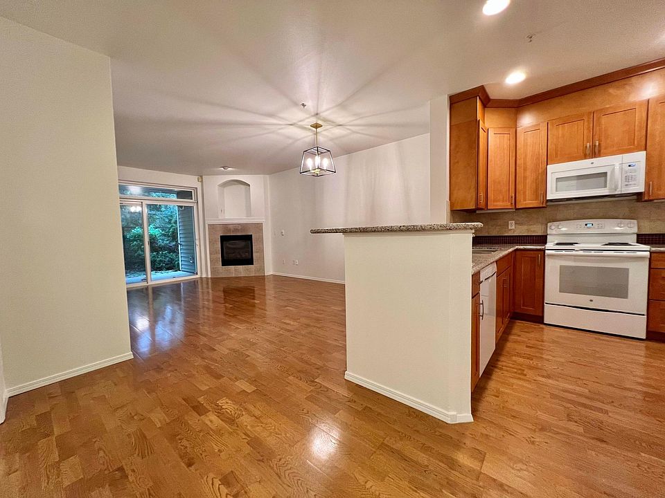 Open living space with modern kitchen and beautiful laminate wood floors.