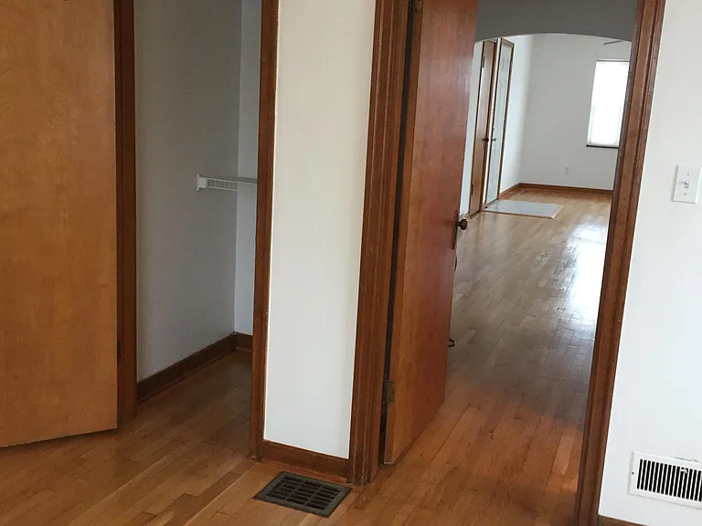 View from inside the bedroom looking toward the dining area and living room. Walk in closet on the left.