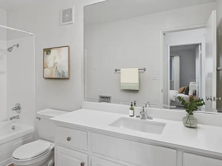 Renovated Package I bath with white quartz countertop, white cabinetry, and hard surface flooring