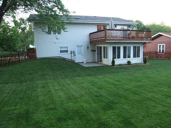 spacious fenced yard with large deck, four season sun room, and patio
