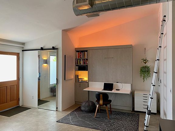 View of entry closet (mirror door), murphy bed/desk combo, flat file storage (right), retractable ladder to access attic storage