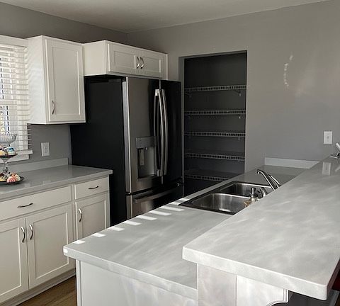 Kitchen with ice maker fridge, walk-in pantry, gas stove and solid surface counter with counter eating an option.