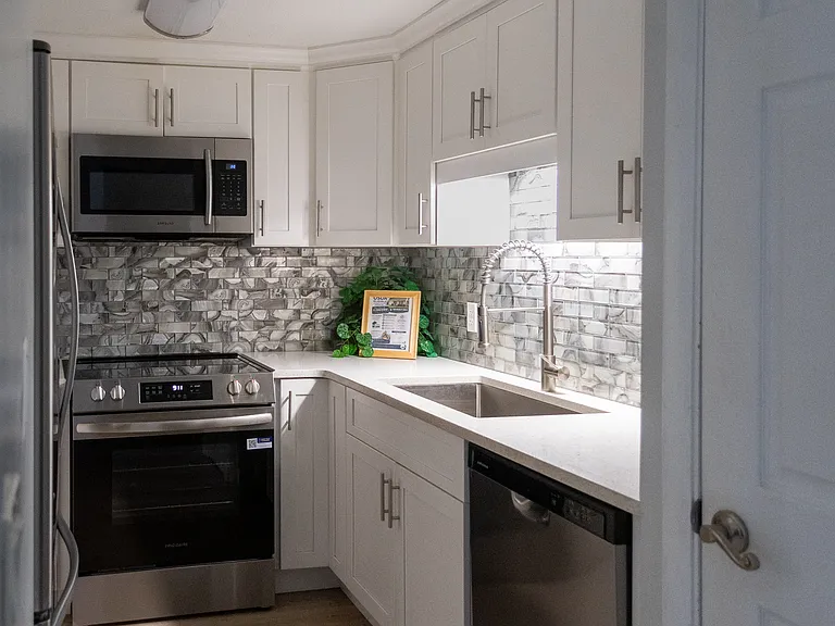 Enjoyed the modern kitchen, with beautiful shaker cabinets, and backsplash. Includes, microwave, glass top stove, refrigerator and dishwasher.