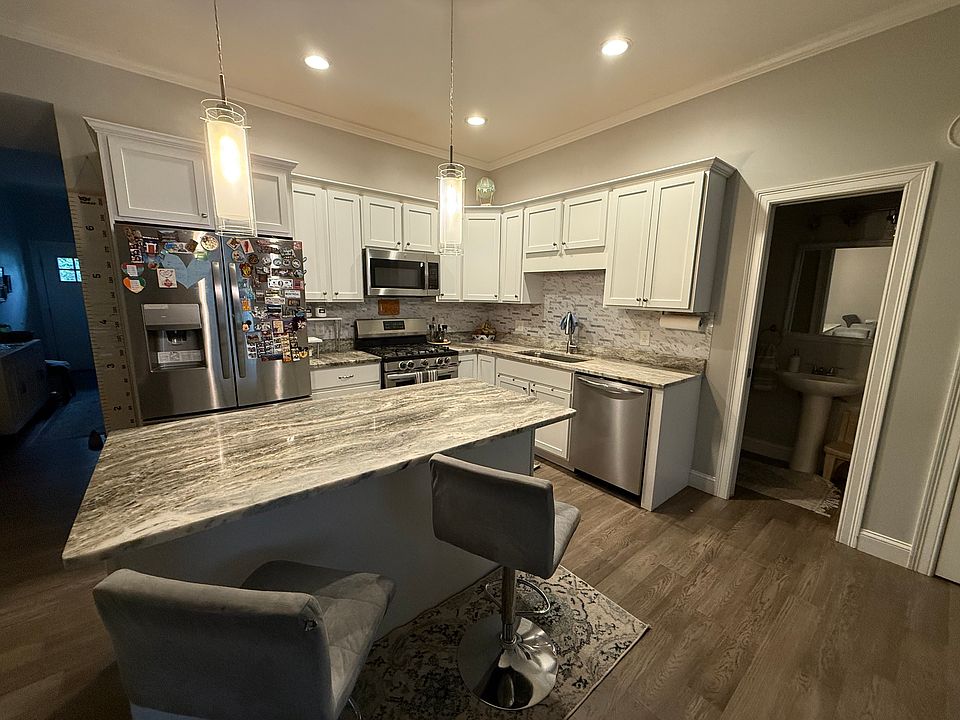 Kitchen with granite countertops and all stainless steel appliances, gas burners