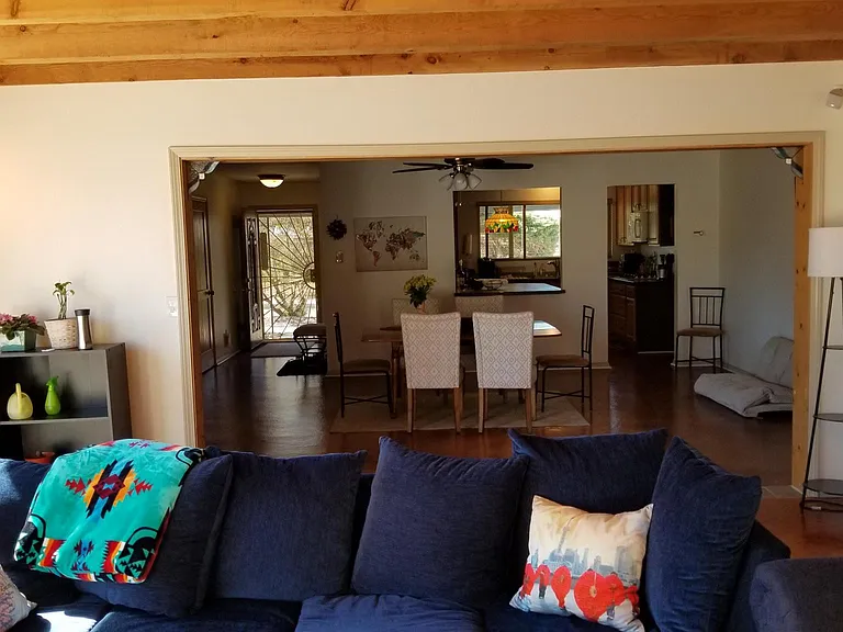 Looking from furnished living room to dining room and into kitchen